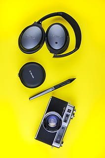 black and gray Bose folding headphones, case, pen, and SLR camera HD wallpaper