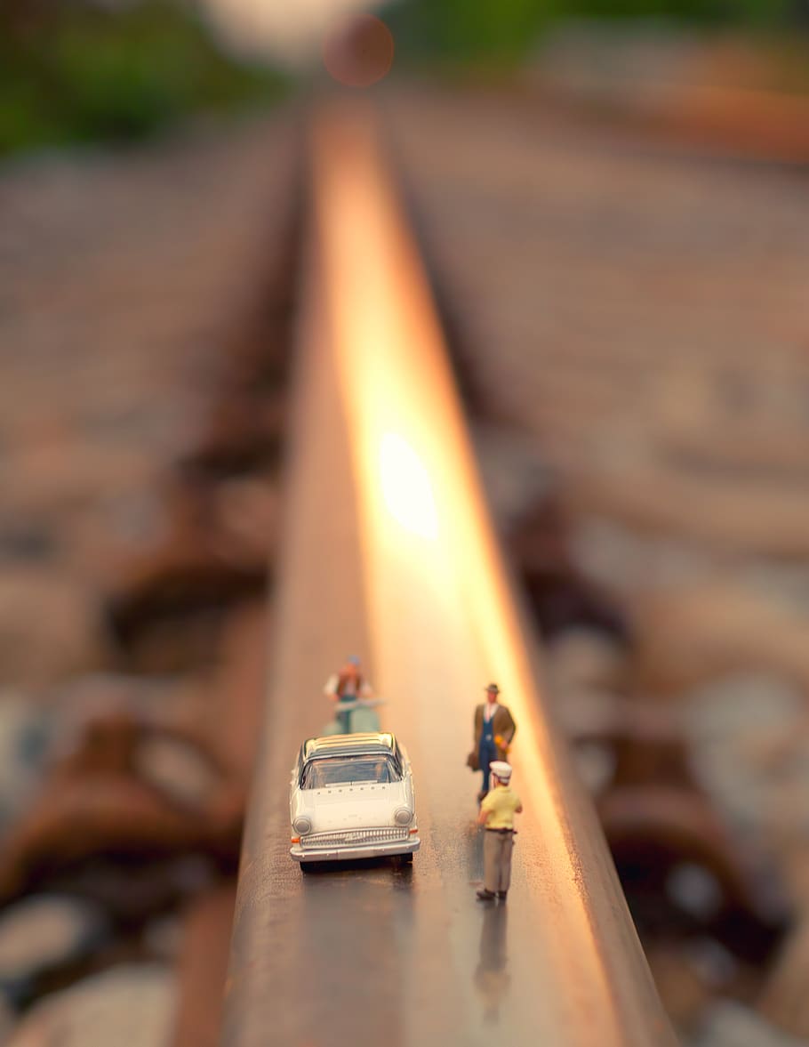 Tilt Shift Lens Photography of White Car and Group of Toy People HD wallpaper