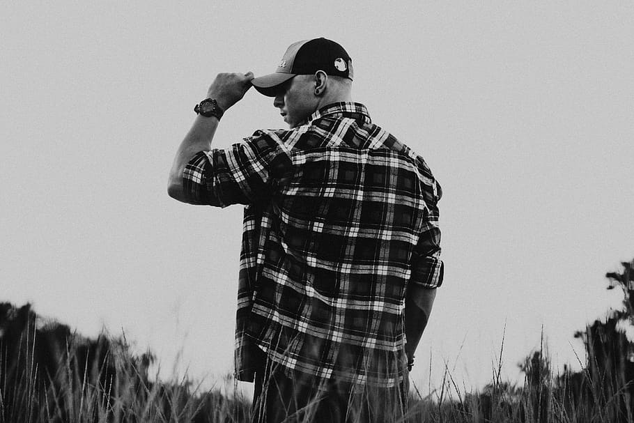 man holds cap while standing beside grass, apparel, clothing HD wallpaper