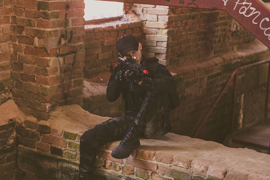 Man In Black Safety Gears Holding And Pointing Airsoft Gun, battle HD wallpaper