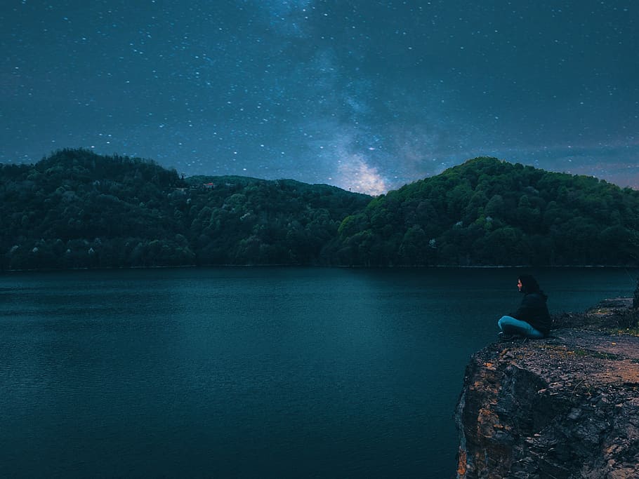 Woman Sitting on Peak Front of Calm Water at Night, cliff, colors