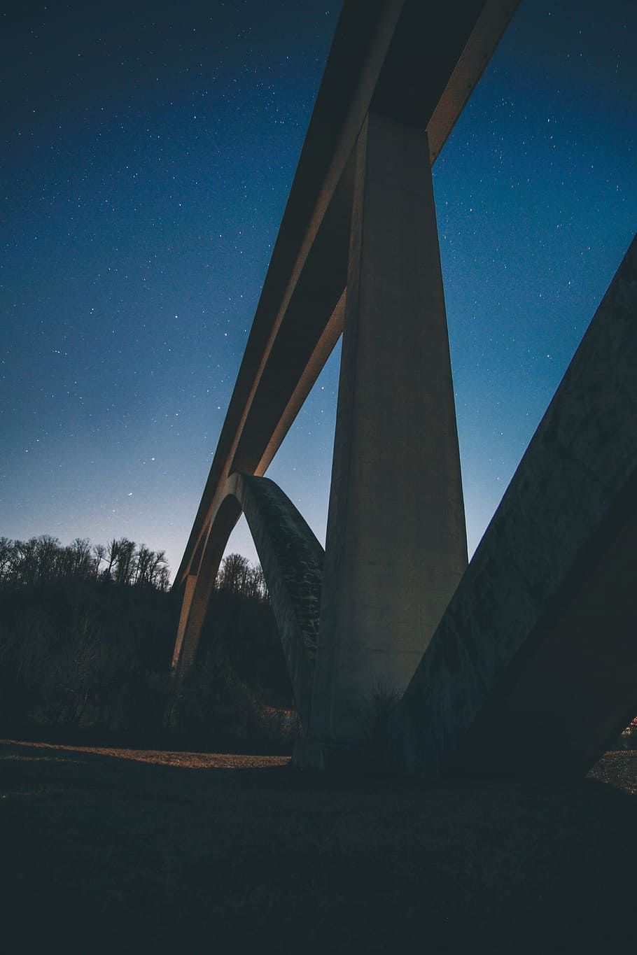 close-up photography of concrete suspension bridge during nighttime HD wallpaper
