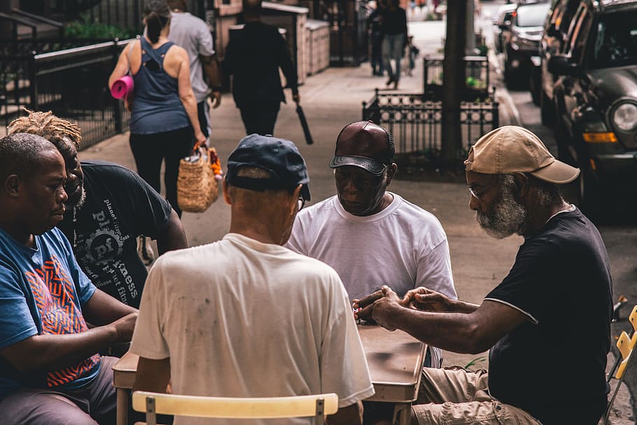 Men Sitting Beside Table on Pathway Near People Walking Beside Rail HD wallpaper