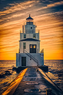lighthouse surrounded by body of water during golden hour, sky HD wallpaper