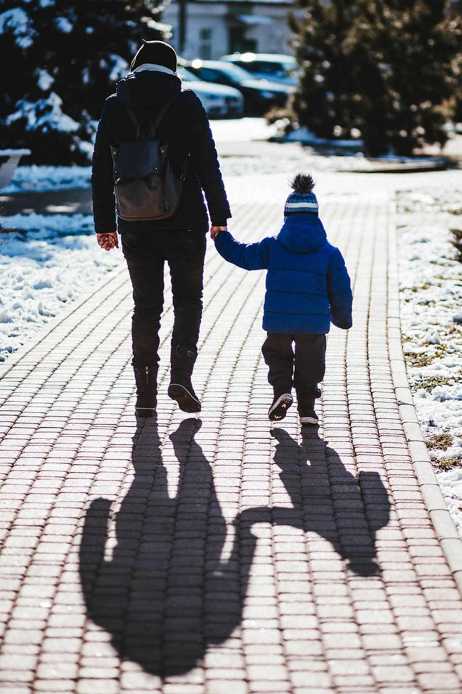 person in black jacket holding hand with toddler, human, holding hands