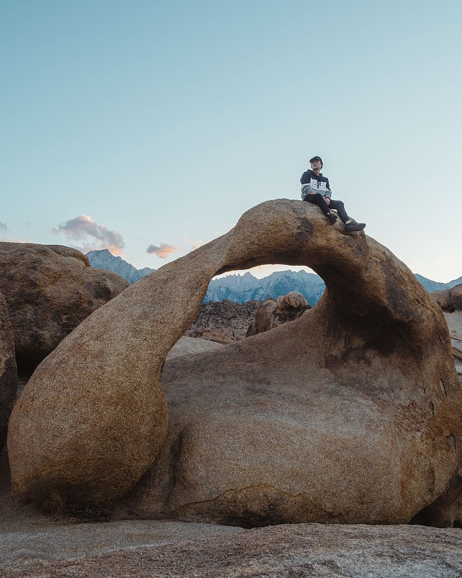 man sitting on rock structure, arch, person, desert, mountain HD wallpaper