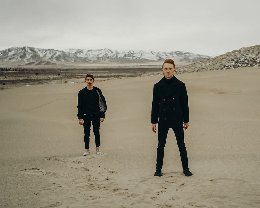 two person wearing black shirt standing on the desert, soil, nature
