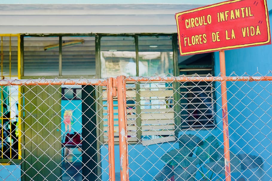 orange and gray fence beside blue concrete building, cuba, havana
