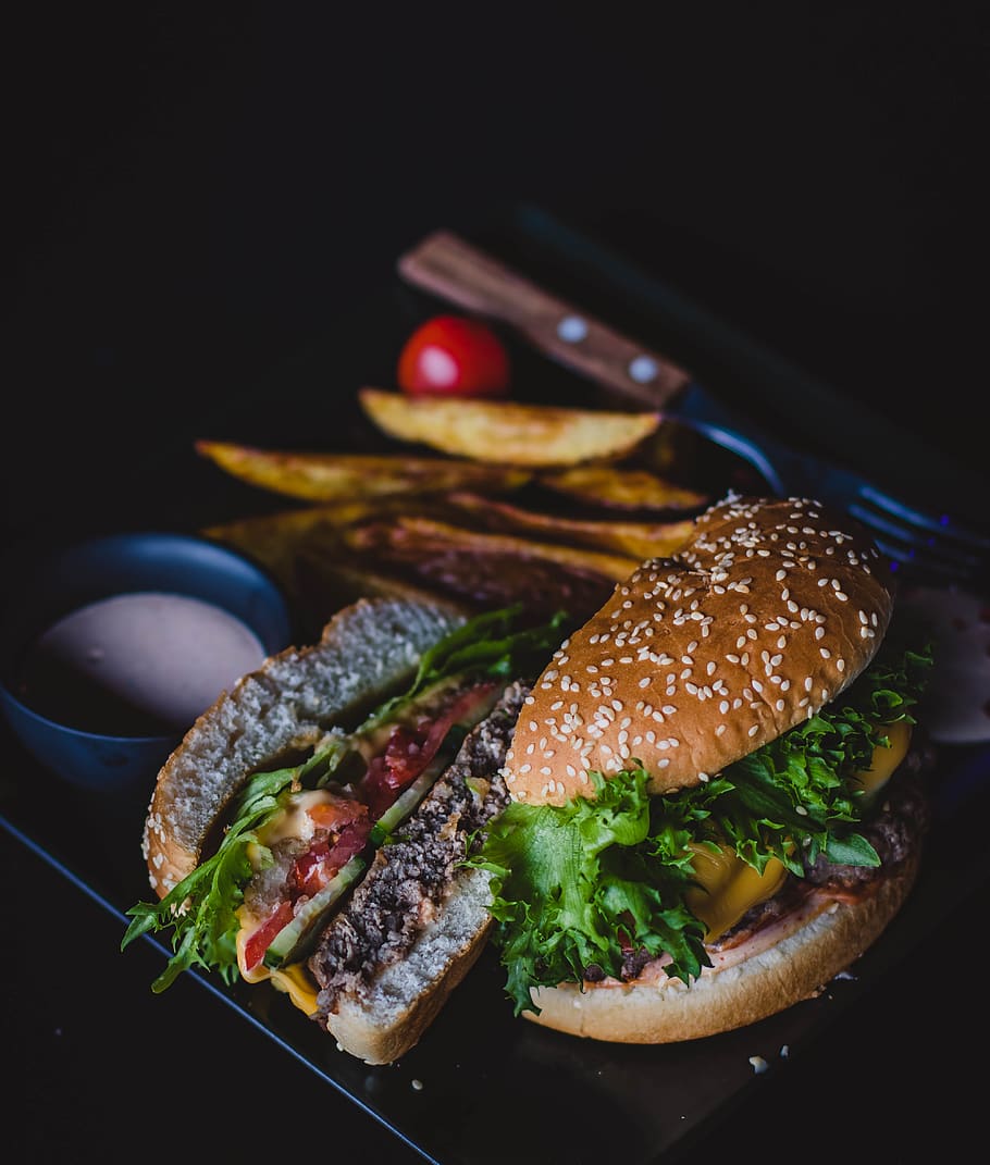 Burger With Green Leafy Vegetable and Cheese on Black Plate, bun