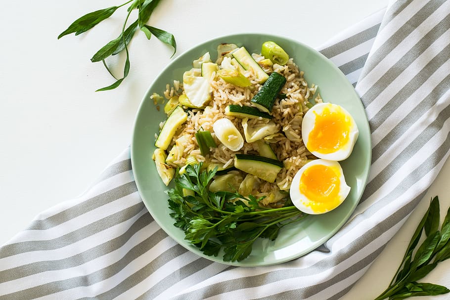 Fried Rice With Poached Egg, Zucchini, And Celery on Round Green Ceramic Plate HD wallpaper
