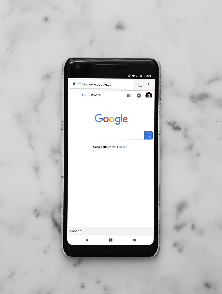 black Android smartphone showing google site on white surface HD wallpaper