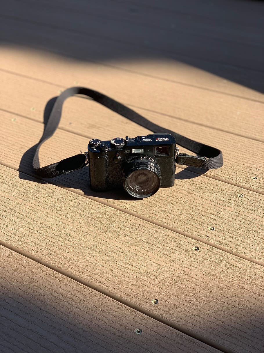 black SLR camera with strap on brown surface, electronics, wood HD wallpaper