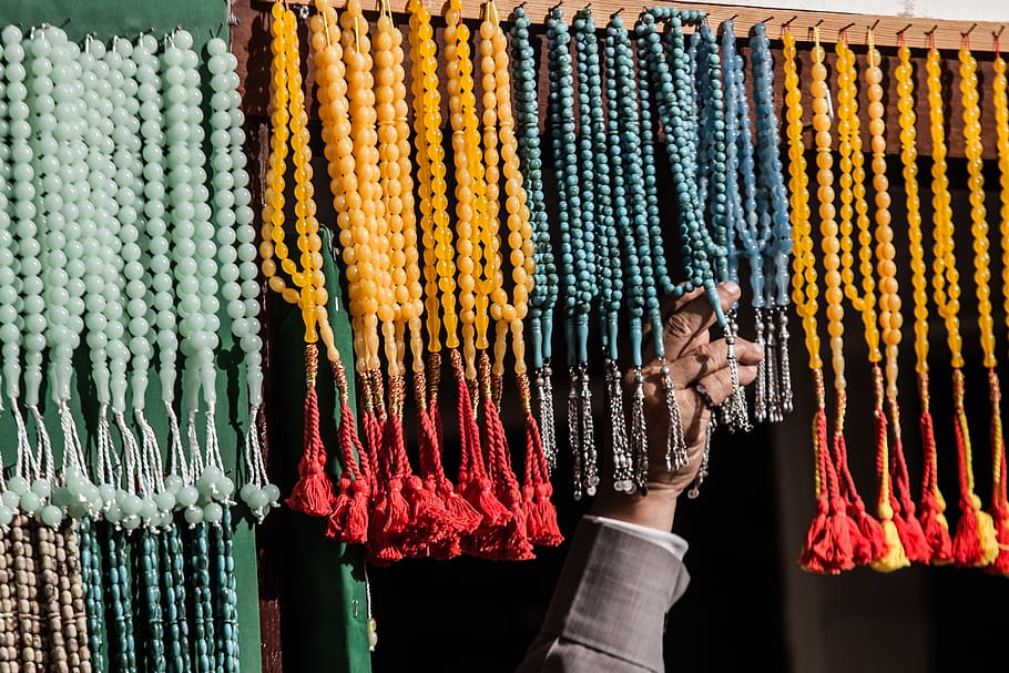 person touching prayer beads, accessories, accessory, worship