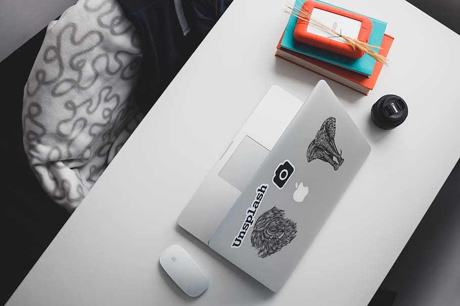 opened silver MacBook, laptop, desk, paper, lens, books, hard drive HD wallpaper