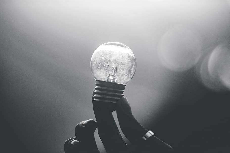 Holding up a small lightbulb., light bulb, lighting equipment HD wallpaper