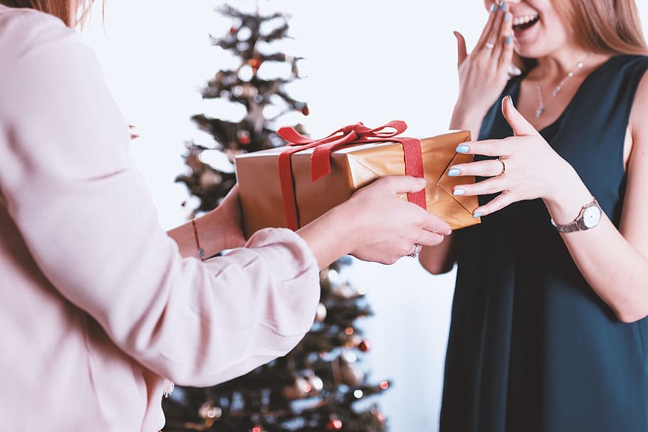 Happy and surprised woman receiving a gift. Merry Christmas, women