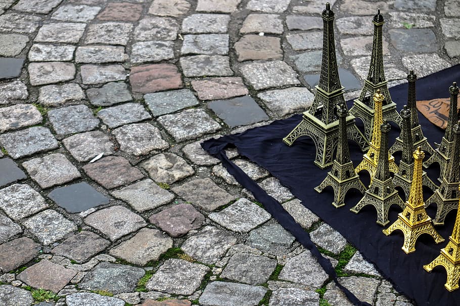 Cobblestone streets with tourist souvenir Eiffel Tower models for sale in Paris, France