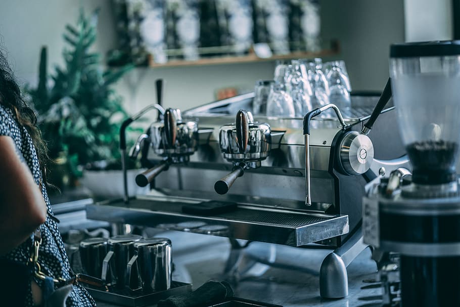 person-standing-near-coffee-machine-inside-room.jpg