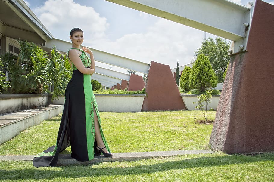 Woman in Green and Black Dress Standing in Front of Wall, beautiful