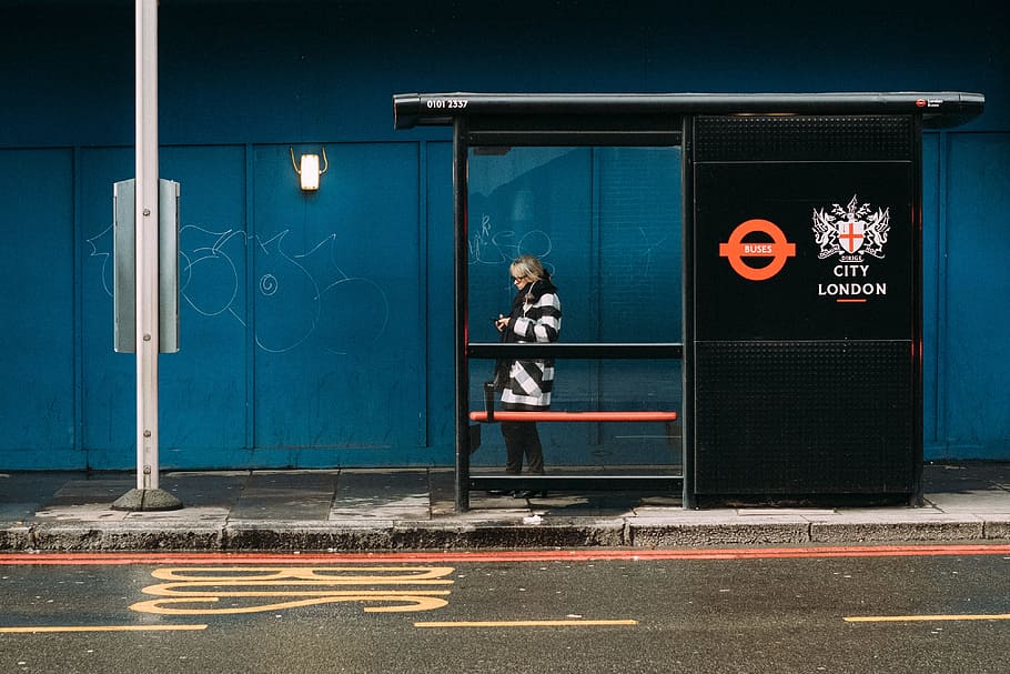 woman standing on waiting station, bus, urban, bus stop, blue
