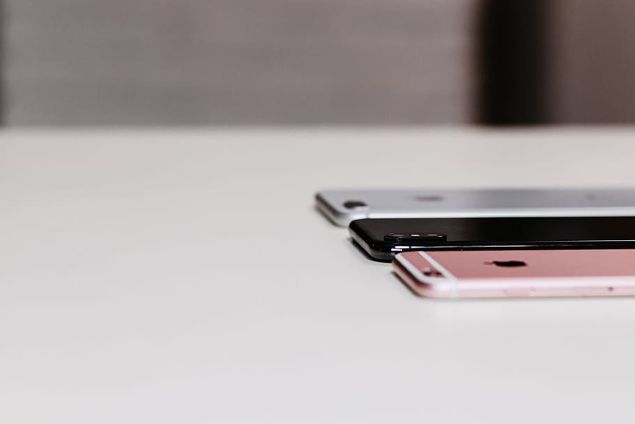 Three Assorted-color Iphone on White Wooden Desk, connection HD wallpaper