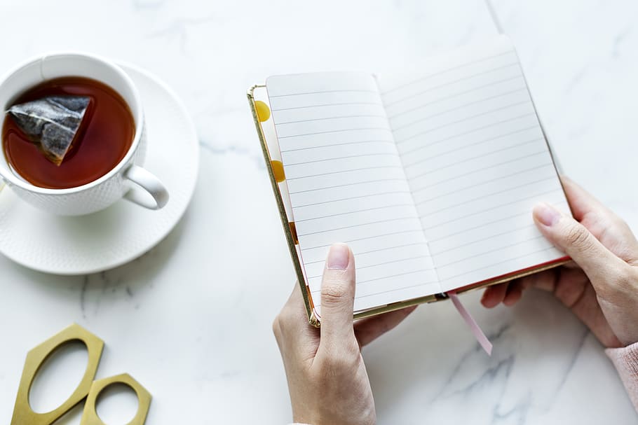Person Opened a Book Near White Ceramic Cup Filled With Coffee HD wallpaper