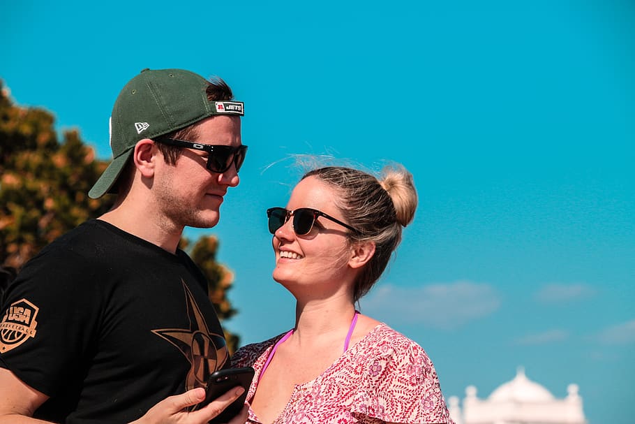 Selective Focus Photo of Couple Stands Behind Green Tree at Daytime HD wallpaper