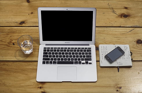MacBook Air beside black iPhone 4 and drinking glass, apple, laptop HD wallpaper