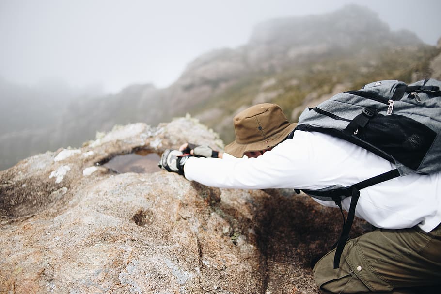 man climbing on brown mountain while carrying backpack, leisure activities HD wallpaper