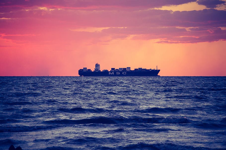 black ship on calm sea during golden hour, freighter, tanker