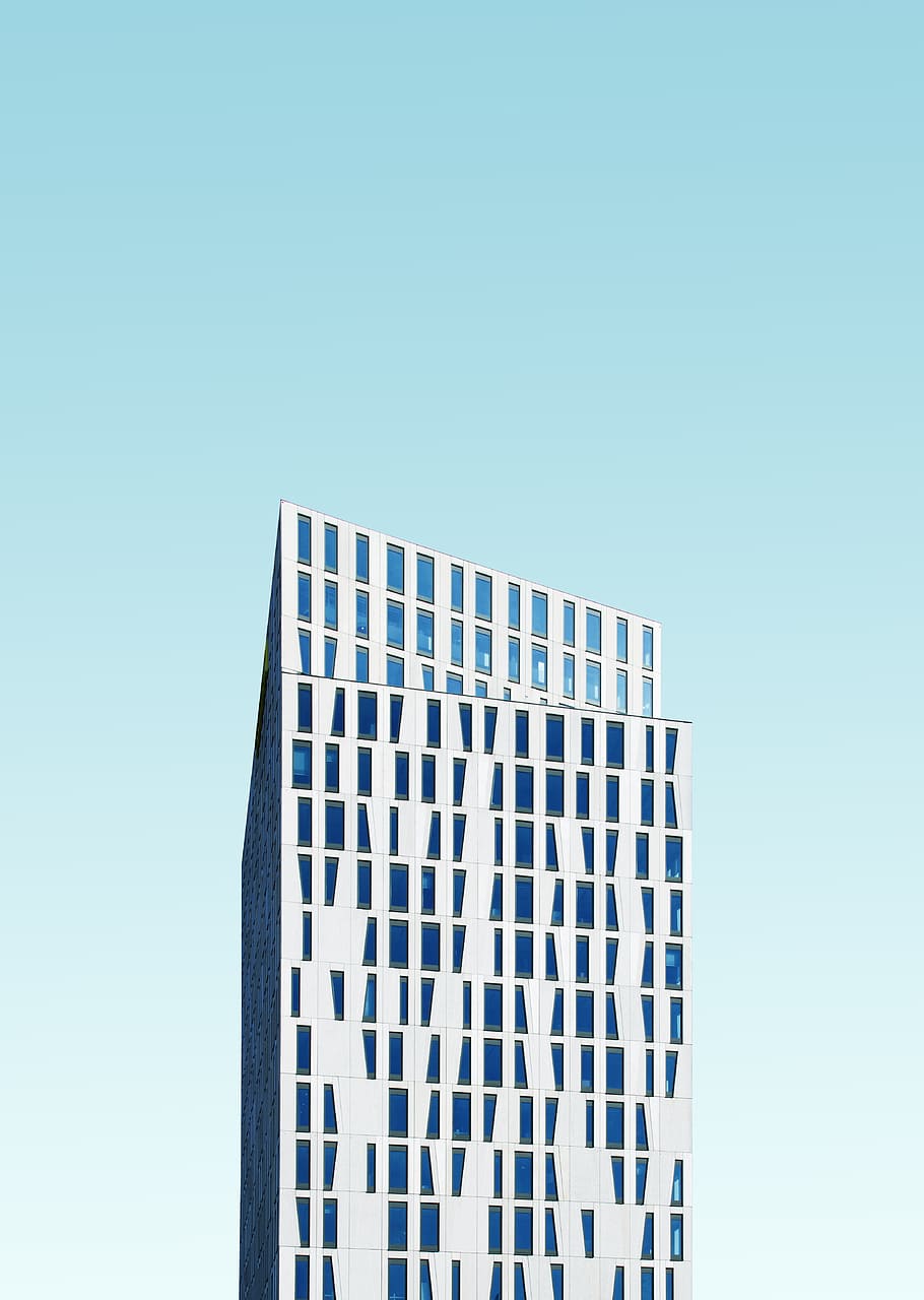 photo of white concrete building under blue sky at daytime, skyscraper