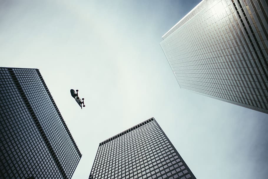 Pesrpective view of skateboard in the air with skyscrapers, architecture HD wallpaper