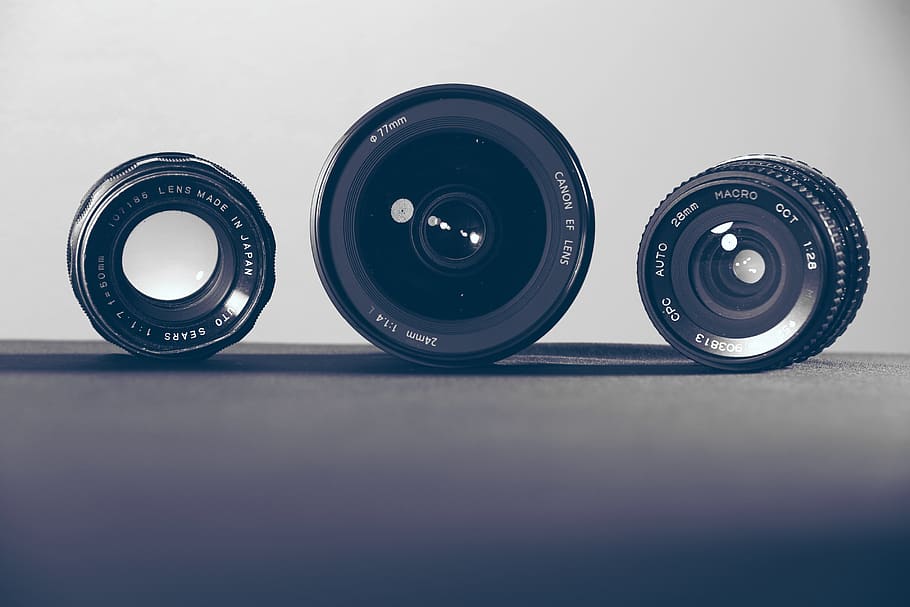 three black camera lenses on gray surface, still life, indoors HD wallpaper