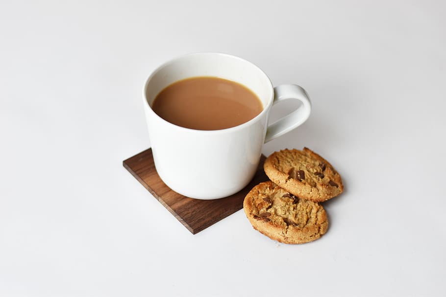 mug with coffee and two cookies on brown coaster, tea, beverage