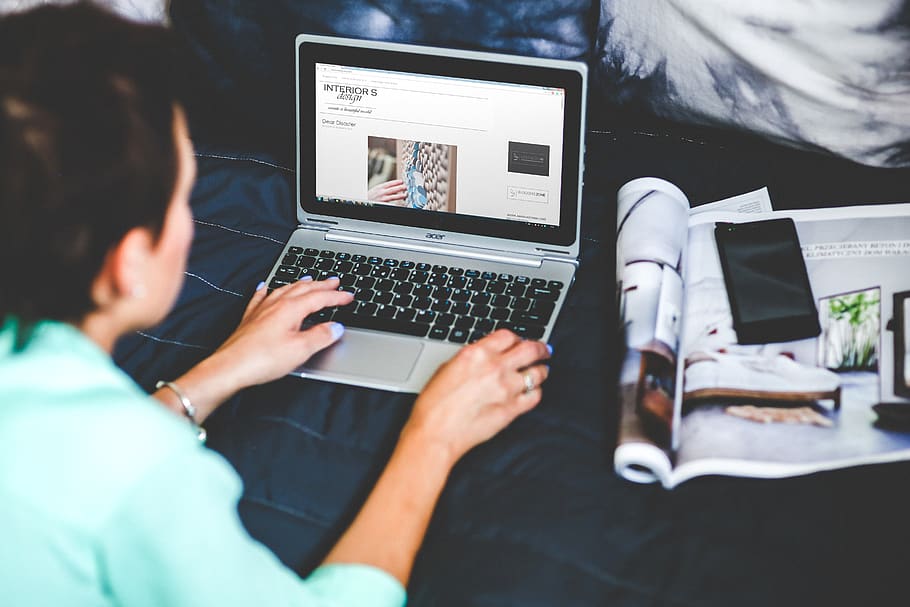 Woman with laptop lying down in bed, blogging, browsing, digital nomad HD wallpaper