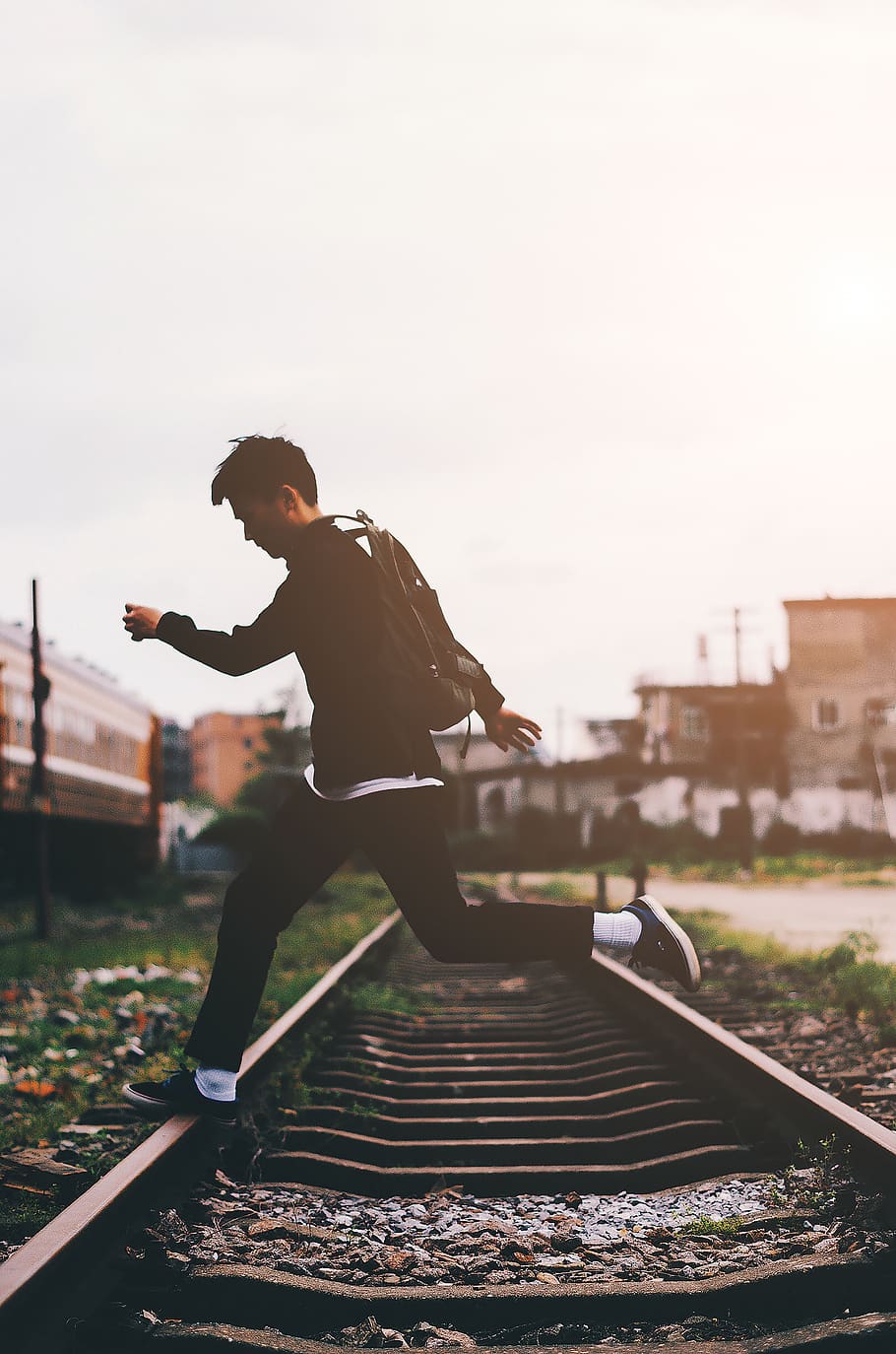 man crossing train track, person, human, people, jump, backpack HD wallpaper