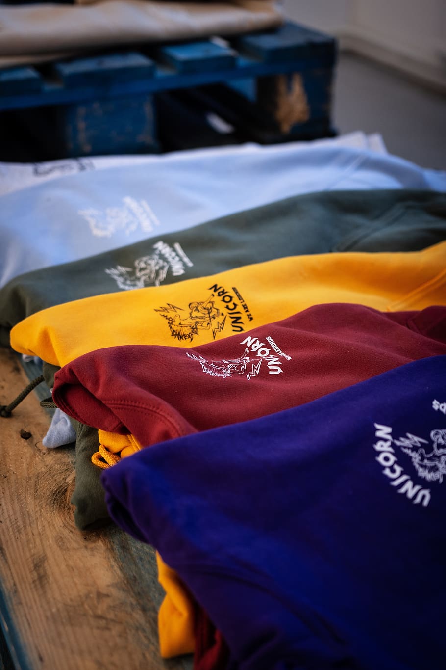 assorted-color shirt lot on brown surface, apparel, clothing HD wallpaper