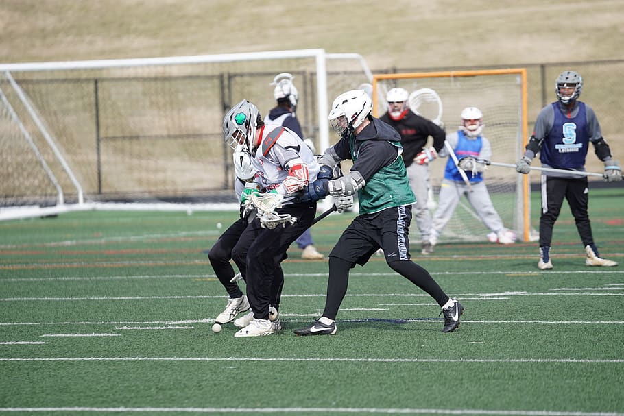 lacrosse players playing on field under white sky, clothing, apparel