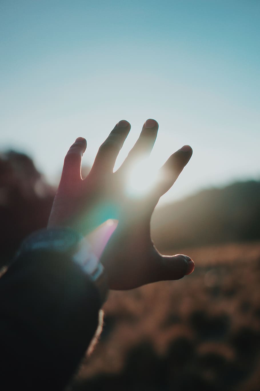 left person hand and bright light, sun, sunset, sunrise, outdoors HD wallpaper
