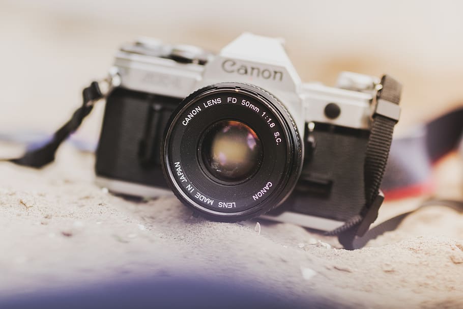 Black and Gray Canon Film Camera on Gray Soil, analog camera HD wallpaper