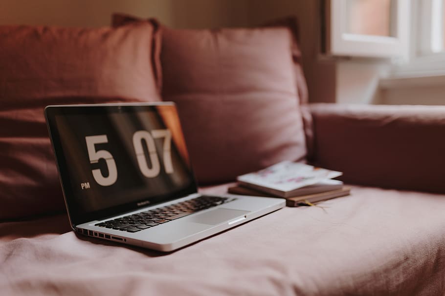 Workplace with a laptop on a pink couch, macbook, macbook pro HD wallpaper