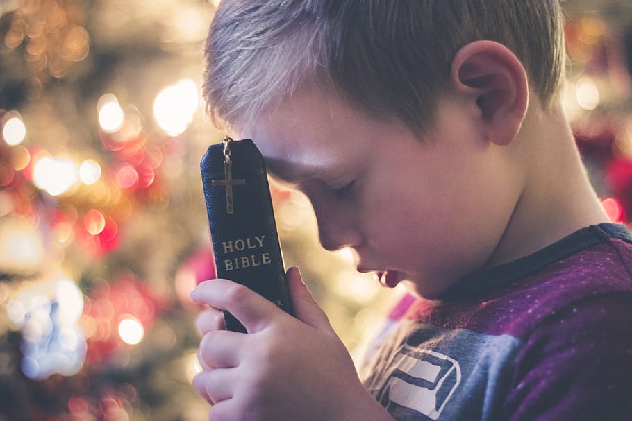 boy holding Holy Bible, headshot, child, portrait, childhood