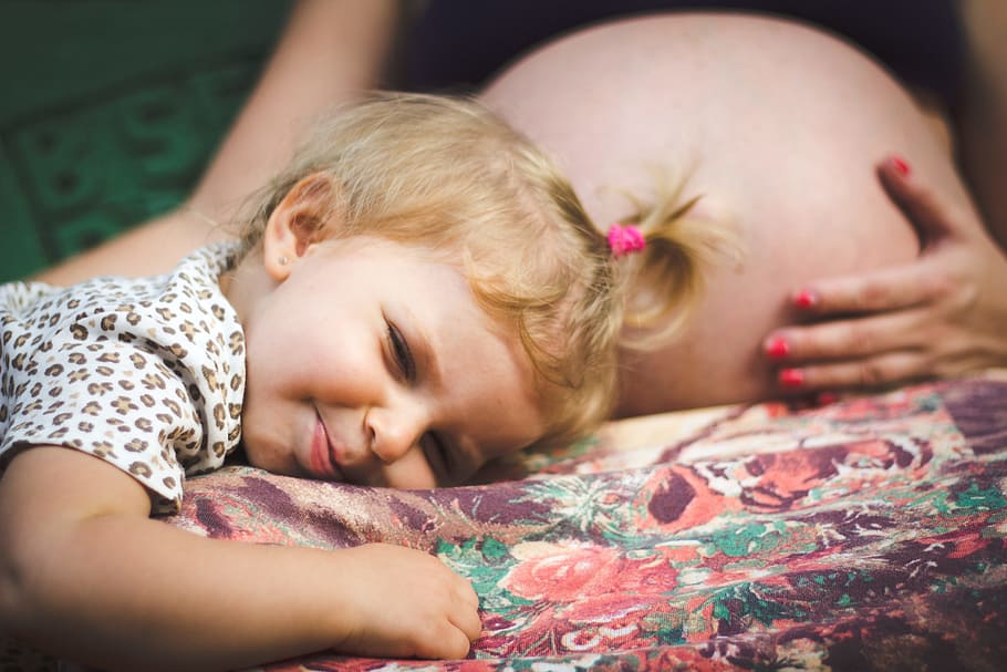 Baby Lying on Pregnant Woman's Lap, bed, bedroom, blond hair