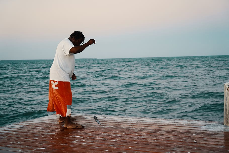 man standing on dock catching fish, clothing, shorts, apparel HD wallpaper