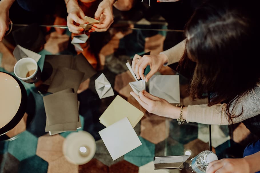 Women folding sheet of paper while making origami, creative, workshop HD wallpaper