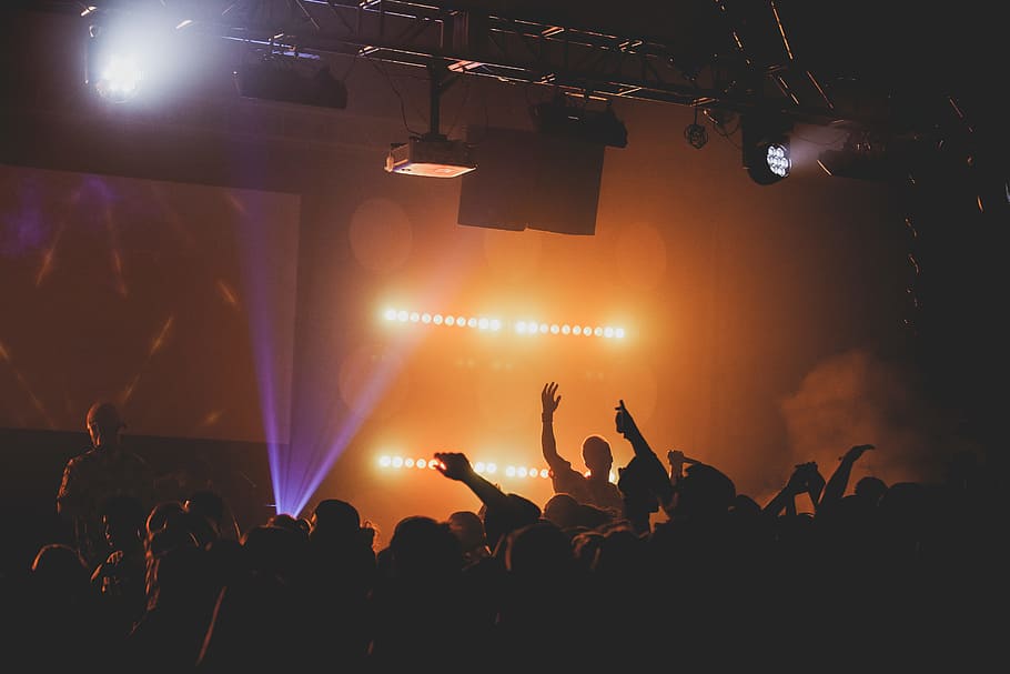 man raising right hand facing crowd, person, light, stage, performer HD wallpaper