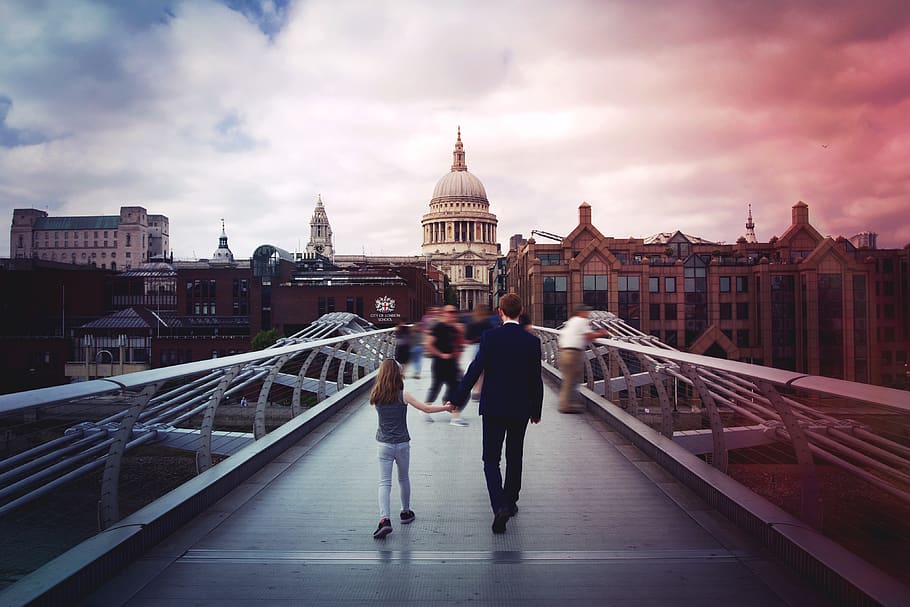 man and girl holding hands while walking on bridge in front of concrete dome building, HD wallpaper