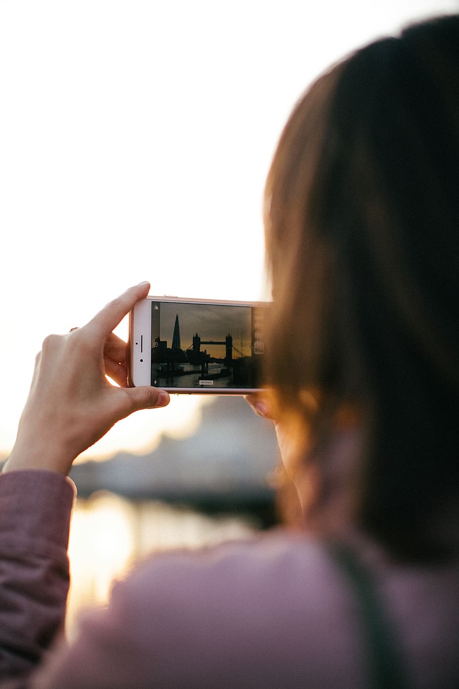 Person Holding White Smartphone While Capturing Tower Bridge at Golden Hour HD wallpaper