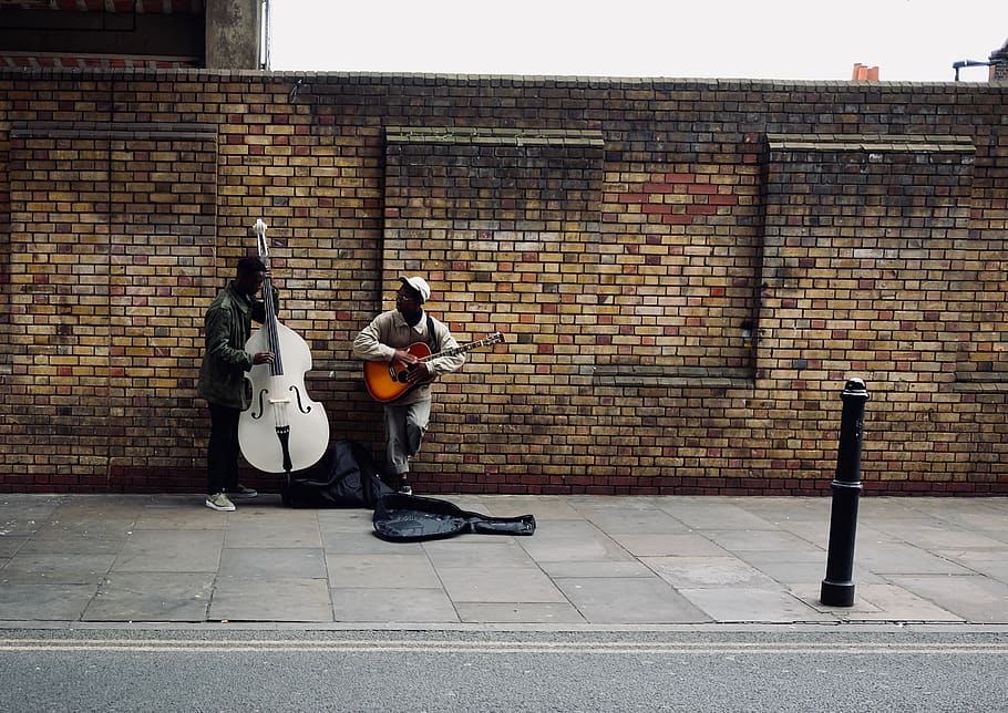 two men playing string instruments beside road, human, person