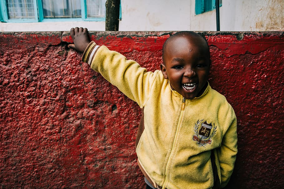 No one's child. Black small boy smiling in Africa wearing Yellow.